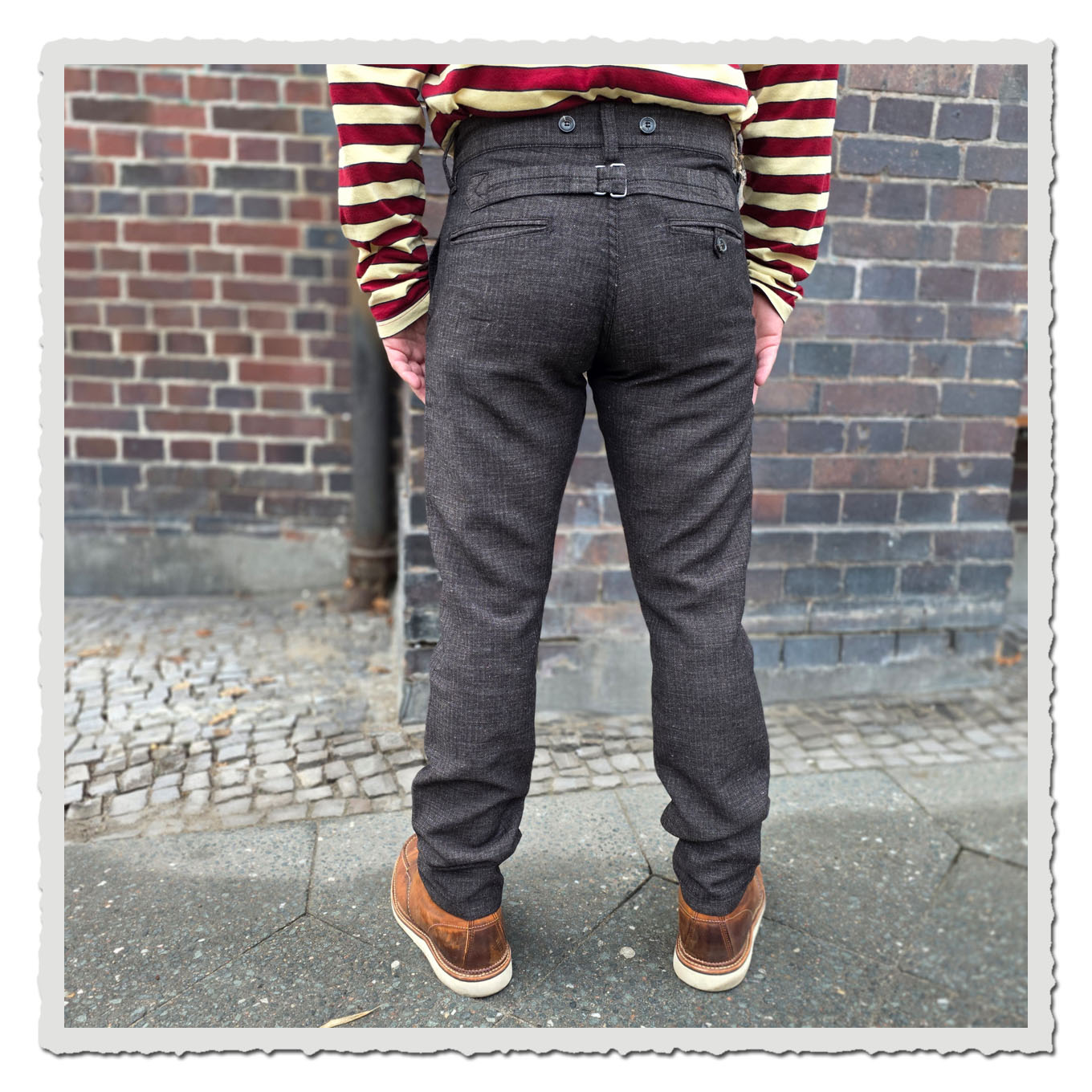 Detailansicht der Beine in Pike Brothers 1947 Harvester Trousers Owen Brown, kombiniert mit robusten Lederboots auf Gehweg